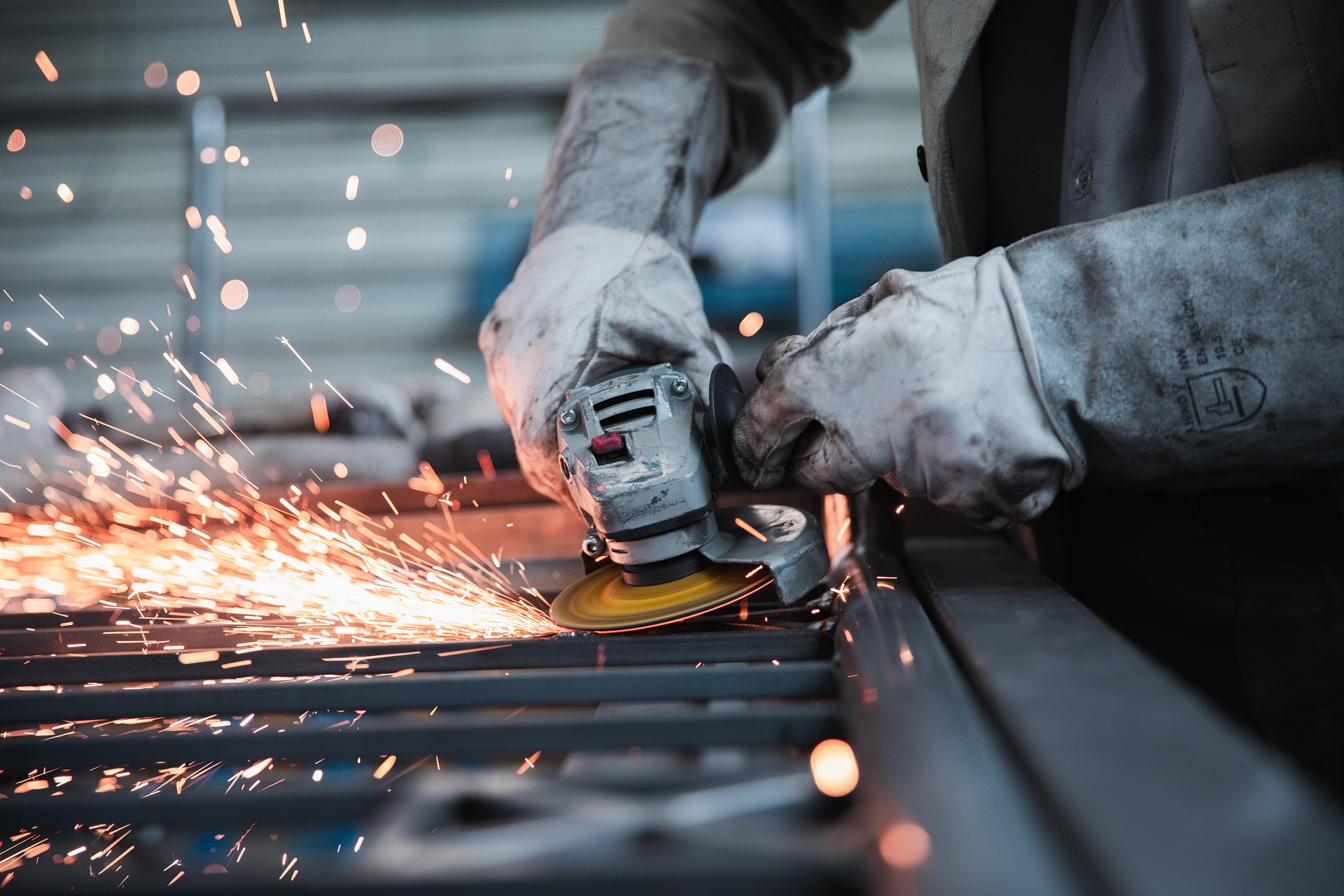 Facharbeiter beim Metallschleifen mit Winkelschleifer — Prokopf Maschinentechnik